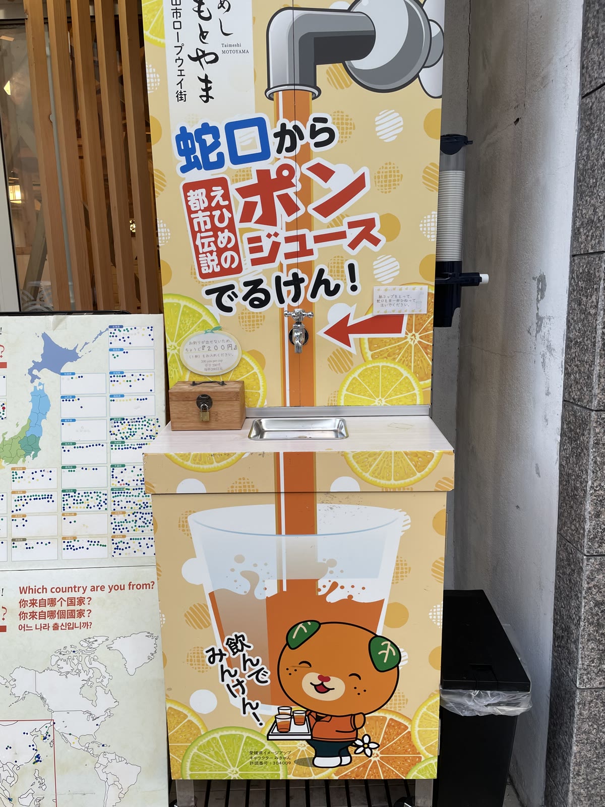 蛇口からみかんジュースが出る無人販売機