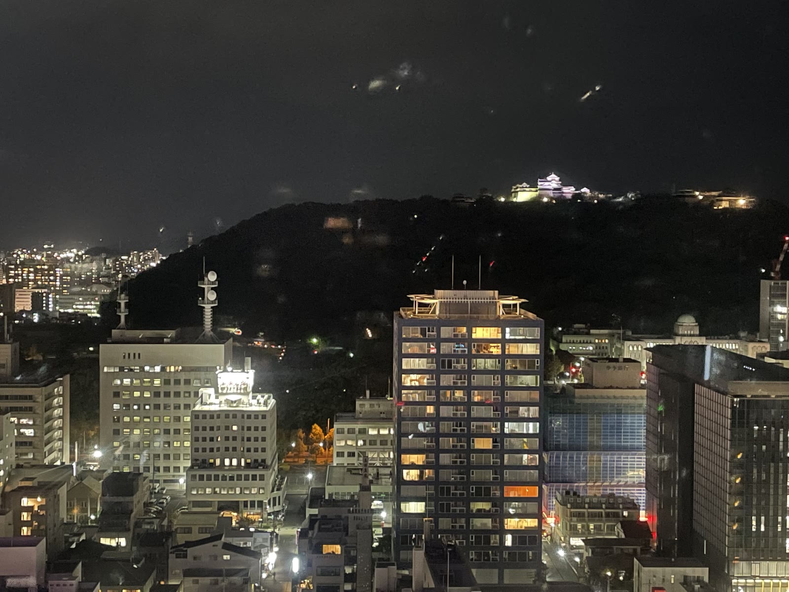 街の向こうの山の上にライトアップされた松山城