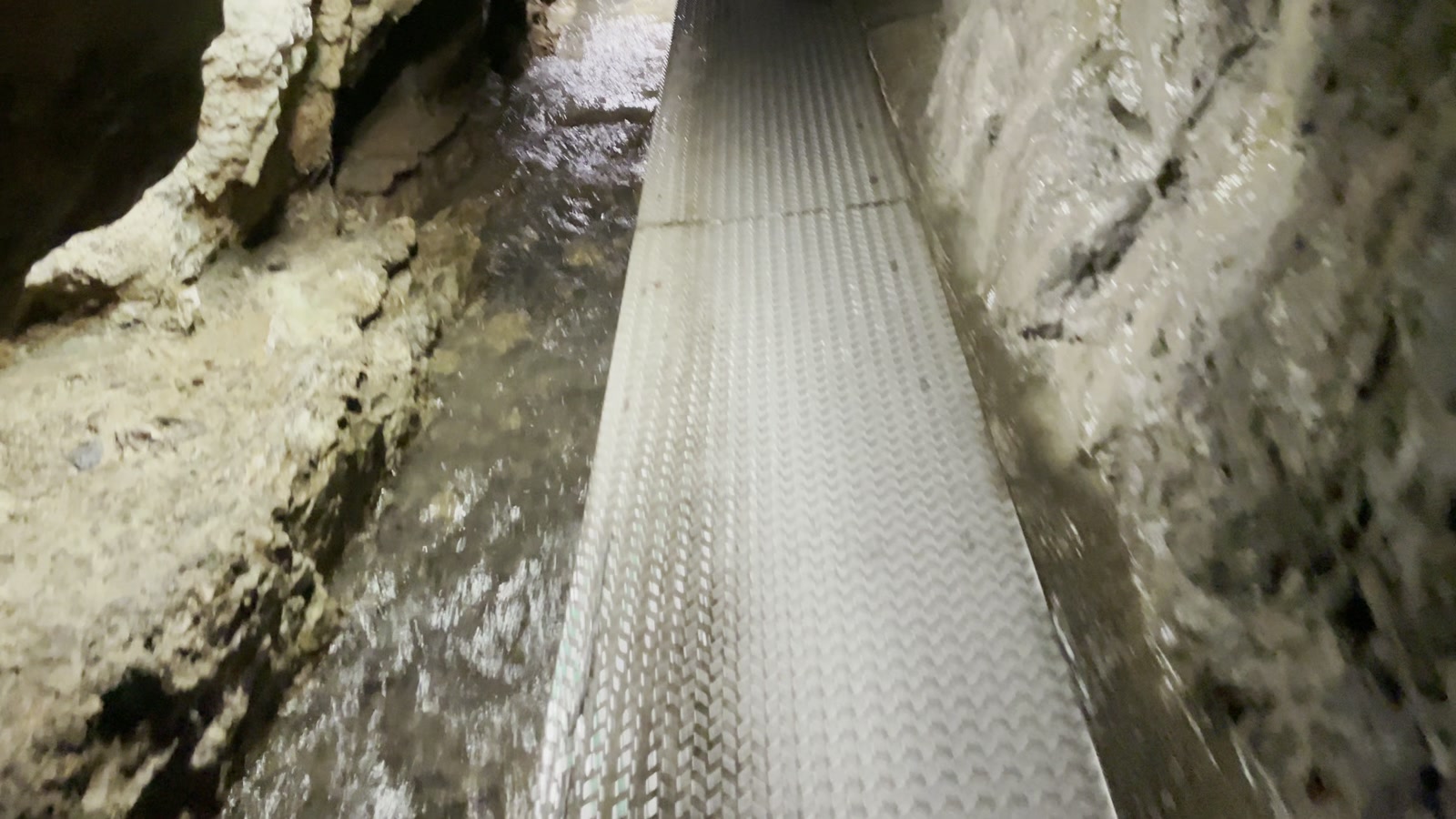金属の足場が続く、狭い洞窟の通路